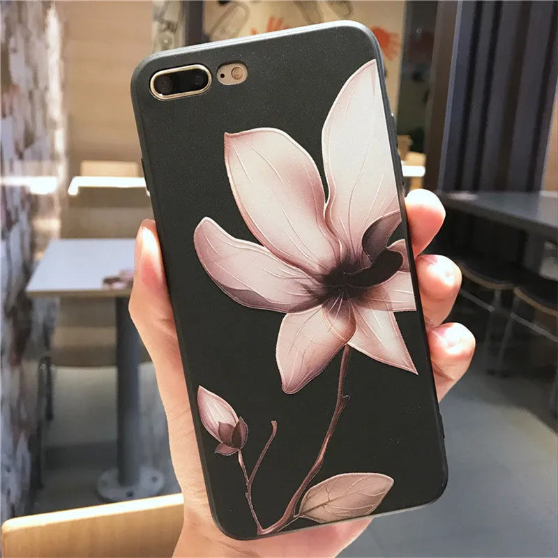 Slim black iPhone case with a single raised embossed flower design on the back.