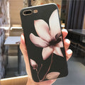 Slim black iPhone case with a single raised embossed flower design on the back.