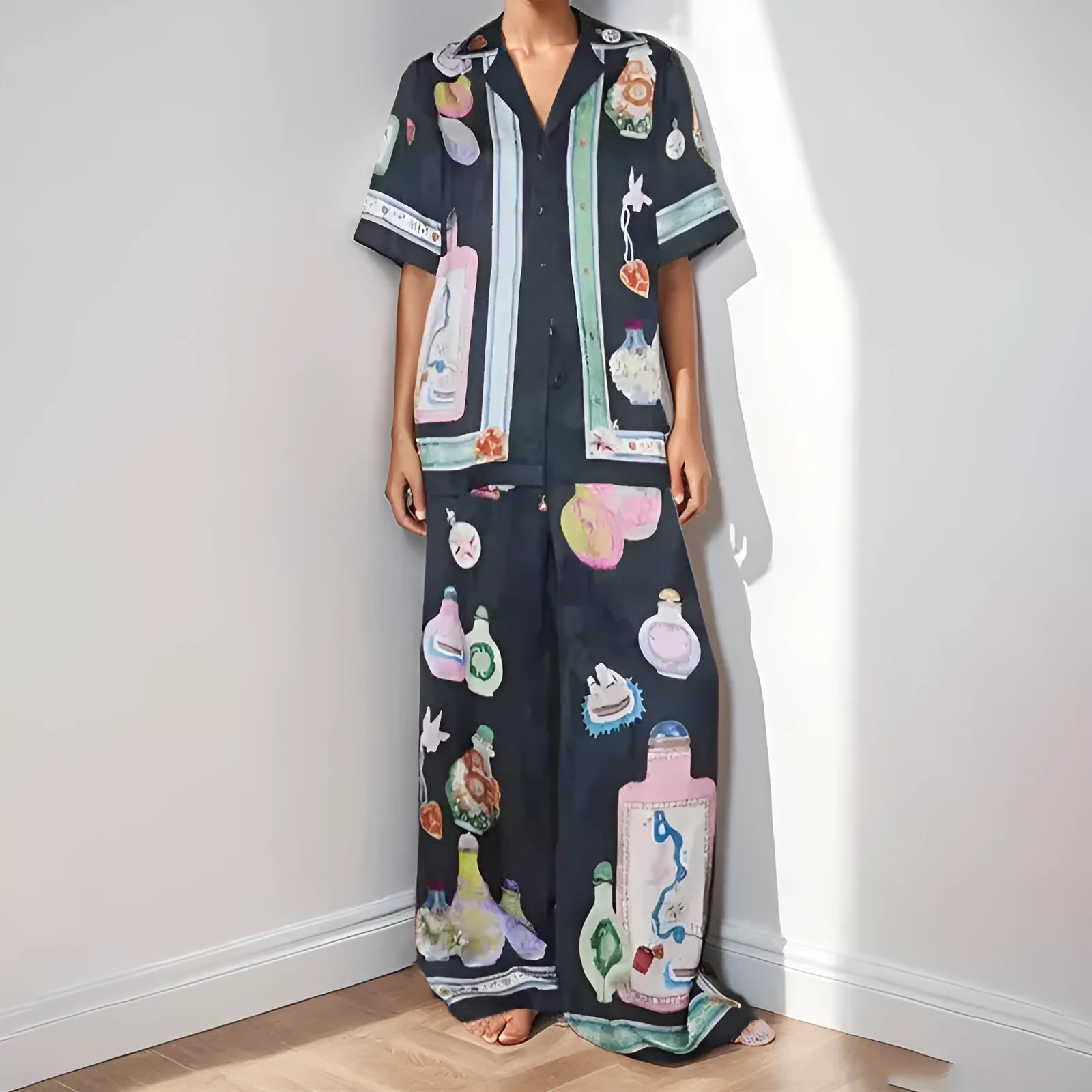 Black women's casual set with cartoon print, featuring sleeveless cardigan and trousers.