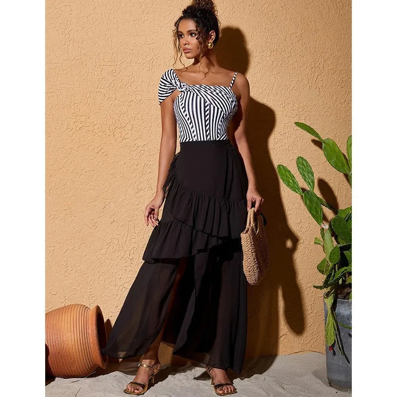 Women's striped one-piece swimsuit with a black ruffle skirt, shown on a mannequin.