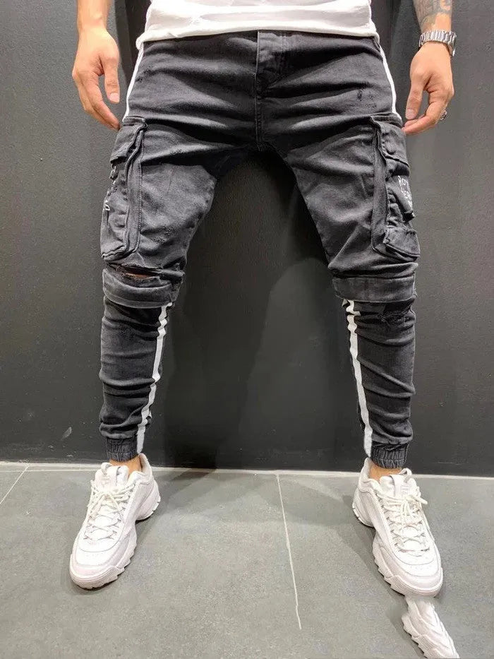 Men's denim knee-cut zipper trousers in black, front view, showing zipper placket and relaxed fit