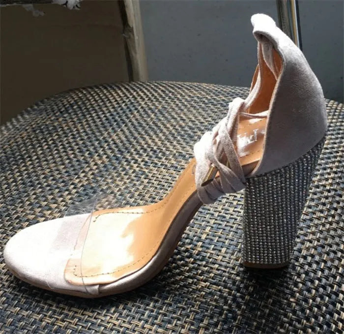 Black and gold pointed toe plastic high heels for women on a white background.