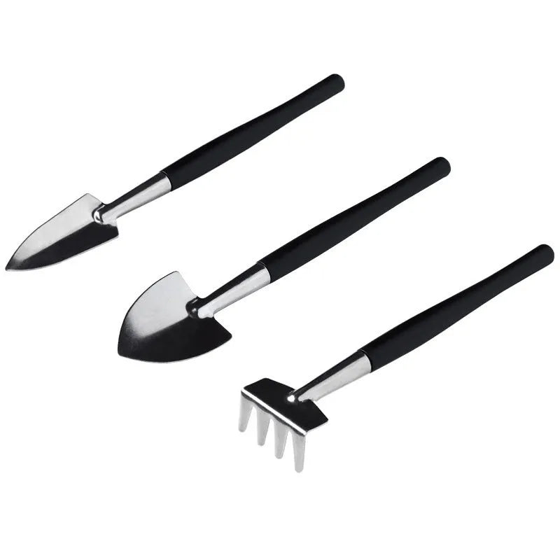 Black plastic and metal succulent plant tool set with 16 pieces including tweezers, shovel, and watering bottle on a grey cushion.