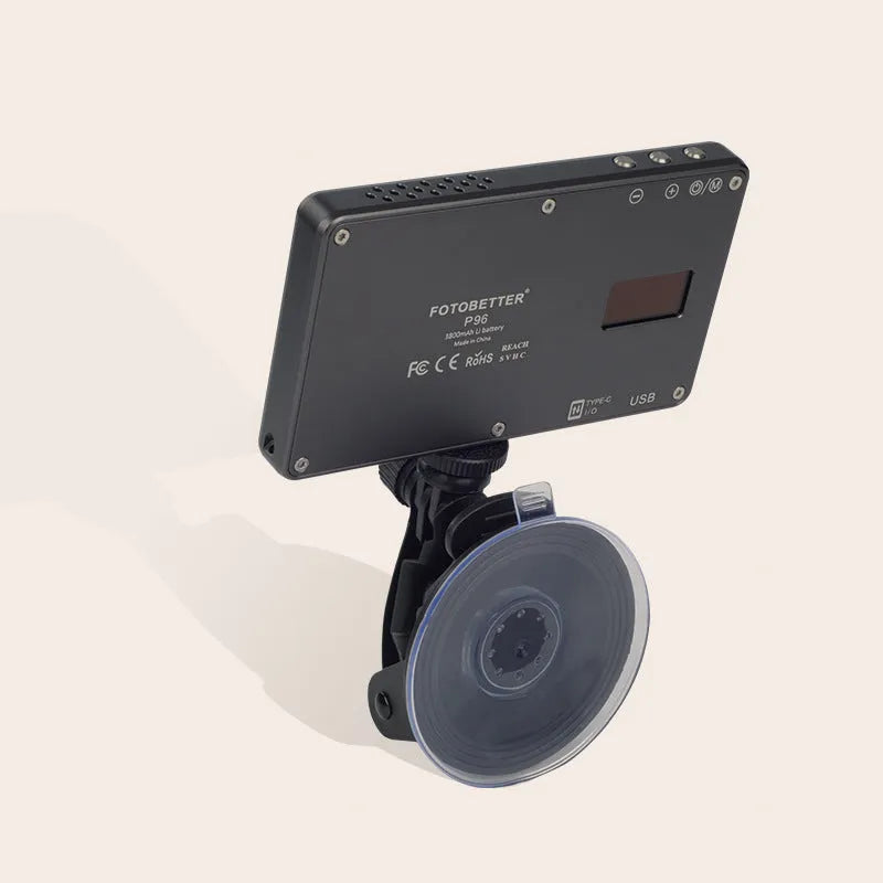 Black aluminium LED video light panel with clip mount, shown illuminating a person on a laptop video call.