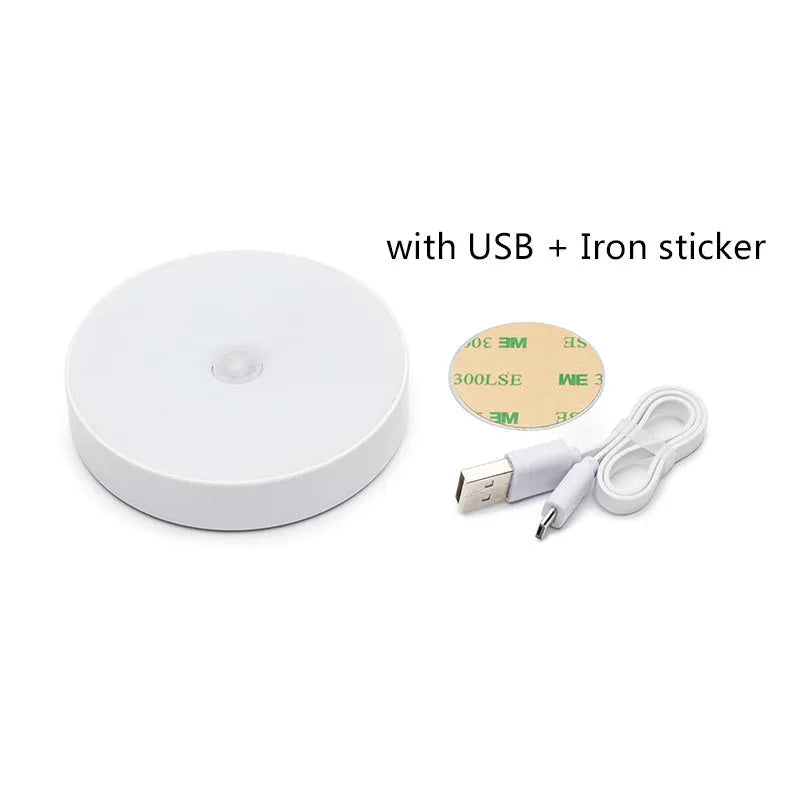 Small white circular USB rechargeable motion sensor LED night light with adhesive backing.