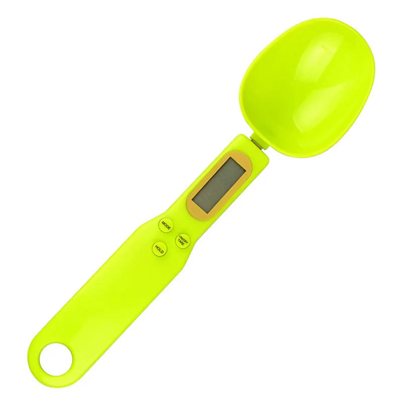 Black electronic measuring spoon scale showing digital display, placed on a kitchen counter.