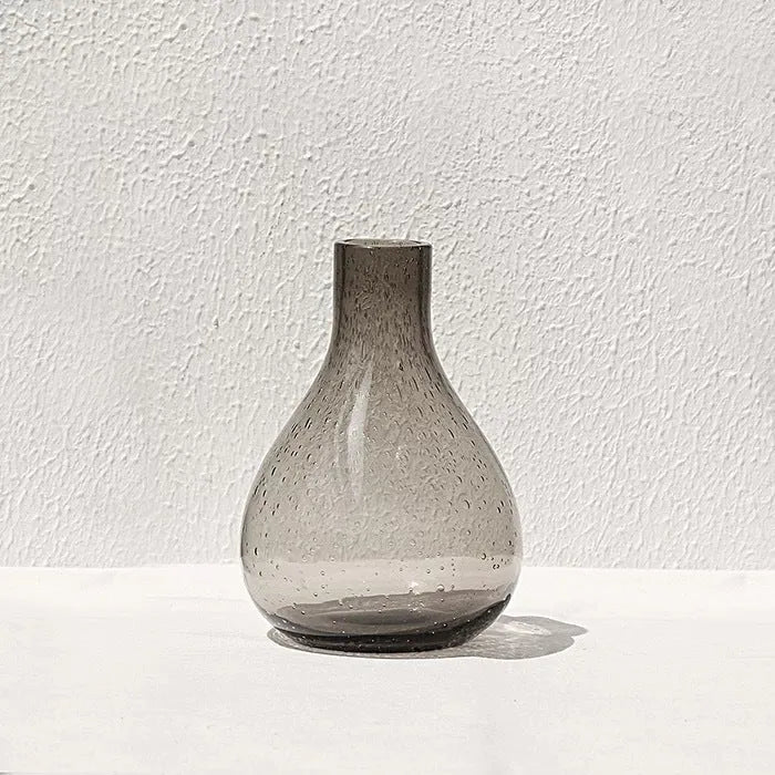 Geometric grey bubble glass vase with a textured surface on a plain background.