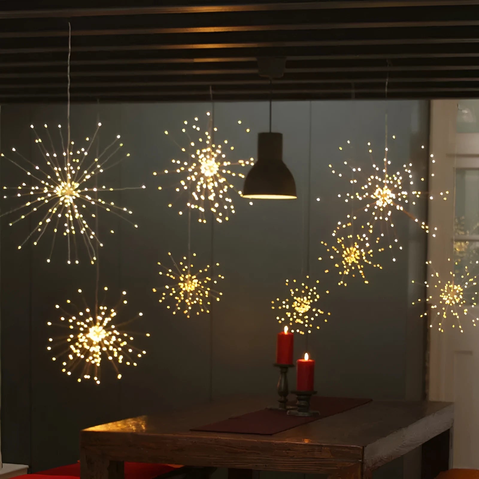 Solar-powered LED meteor shower firework light hanging outdoors with warm white lights.