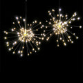 Solar-powered LED meteor shower firework light hanging outdoors with warm white lights.