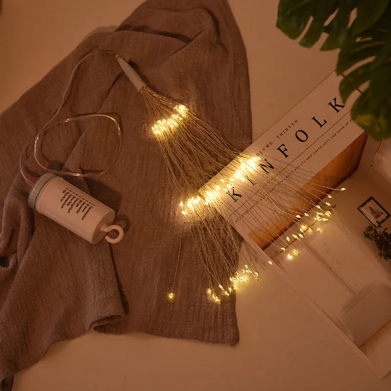 Solar-powered LED meteor shower firework light hanging outdoors with warm white lights.