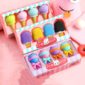 Set of twelve colourful cartoon food-shaped erasers including ice creams, doughnuts, and lollipops.