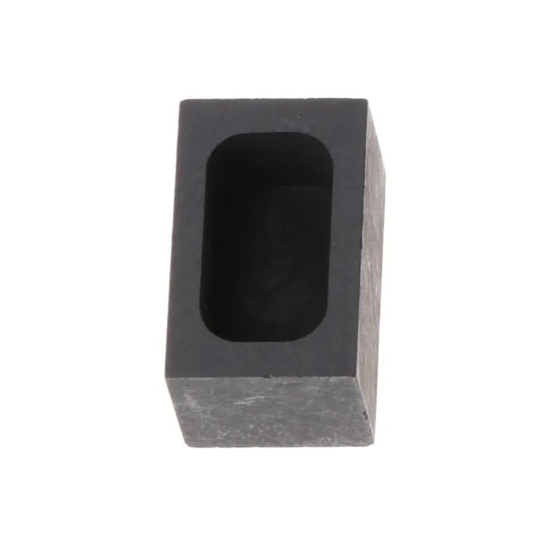 A square graphite crucible or melting pot for gold, silver, and precious metals on a workbench.