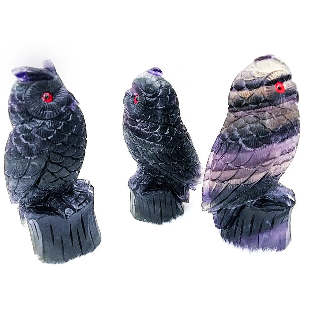Hand carved purple fluorite owl ornament on a neutral background, showing detailed carving and natural crystal colour.