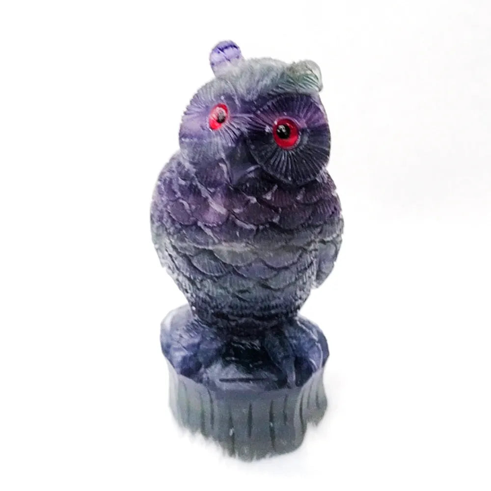 Hand carved purple fluorite owl ornament on a neutral background, showing detailed carving and natural crystal colour.