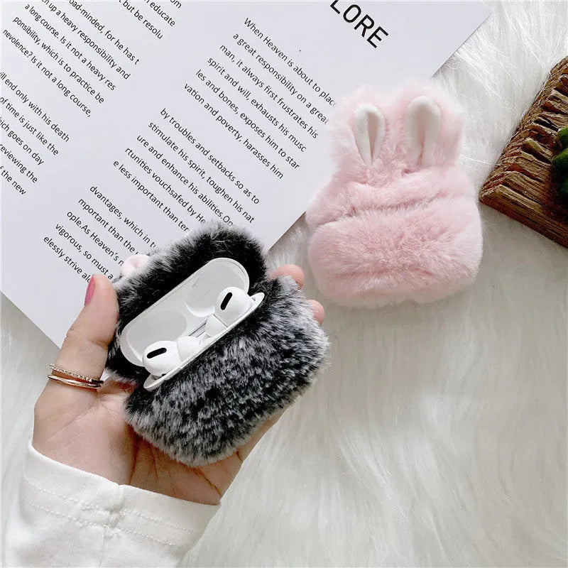 Pink silicone AirPods case with grey plush rabbit ears charm on Apple AirPods charging case