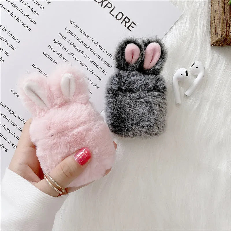 Pink silicone AirPods case with grey plush rabbit ears charm on Apple AirPods charging case
