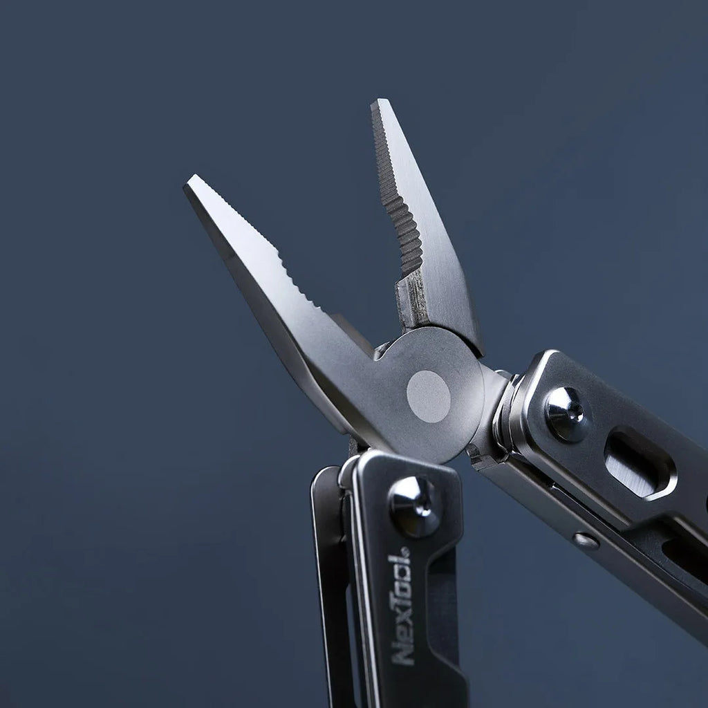 White stainless steel multi-function tool showing integrated wrench, knife blade, and needle nose pliers.