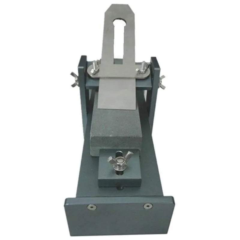 Aluminium alloy fixed angle sharpening tool for woodworking chisels and planer blades on a workbench.