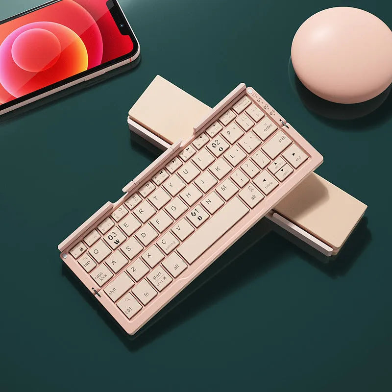 Silver white folding Bluetooth keyboard with built-in stand holding a tablet