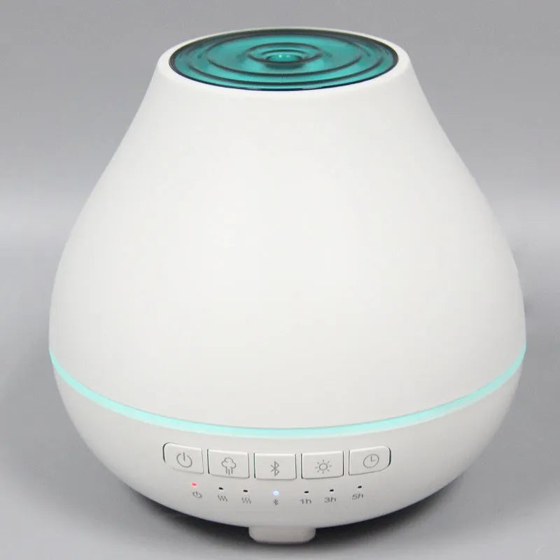White circular Bluetooth humidifier and aroma diffuser with night light on a table.