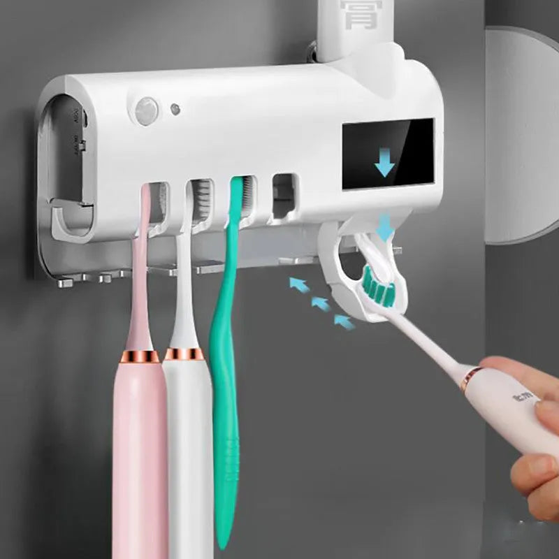 White automatic toothpaste squeezer and toothbrush steriliser unit mounted on bathroom wall