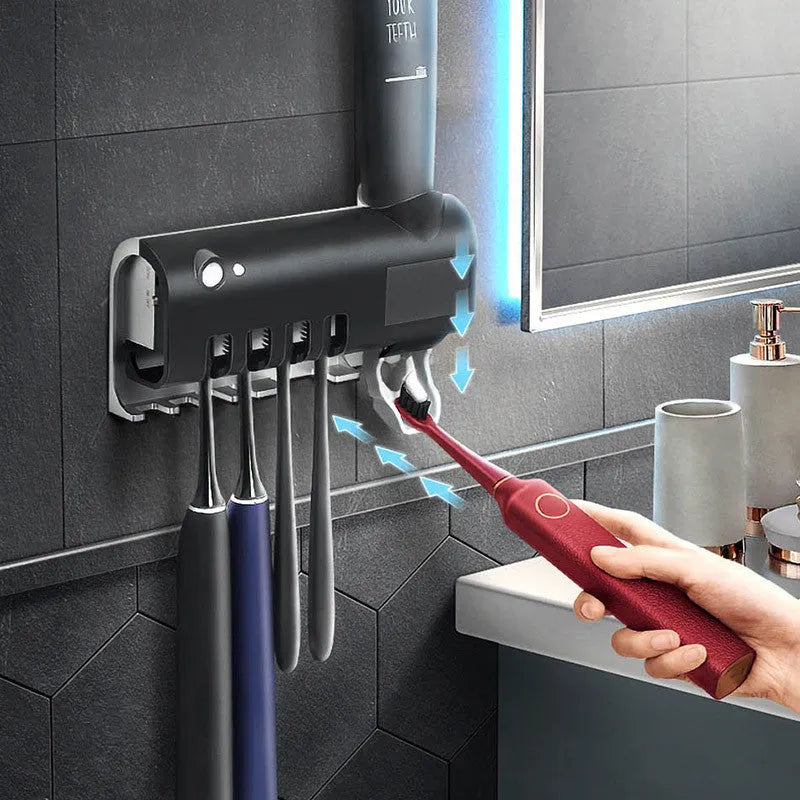 White automatic toothpaste squeezer and toothbrush steriliser unit mounted on bathroom wall