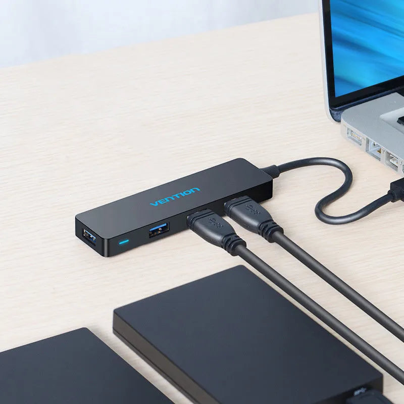 Black USB 3.0 hub with four ports, short attached cable, and nickel-plated connectors.