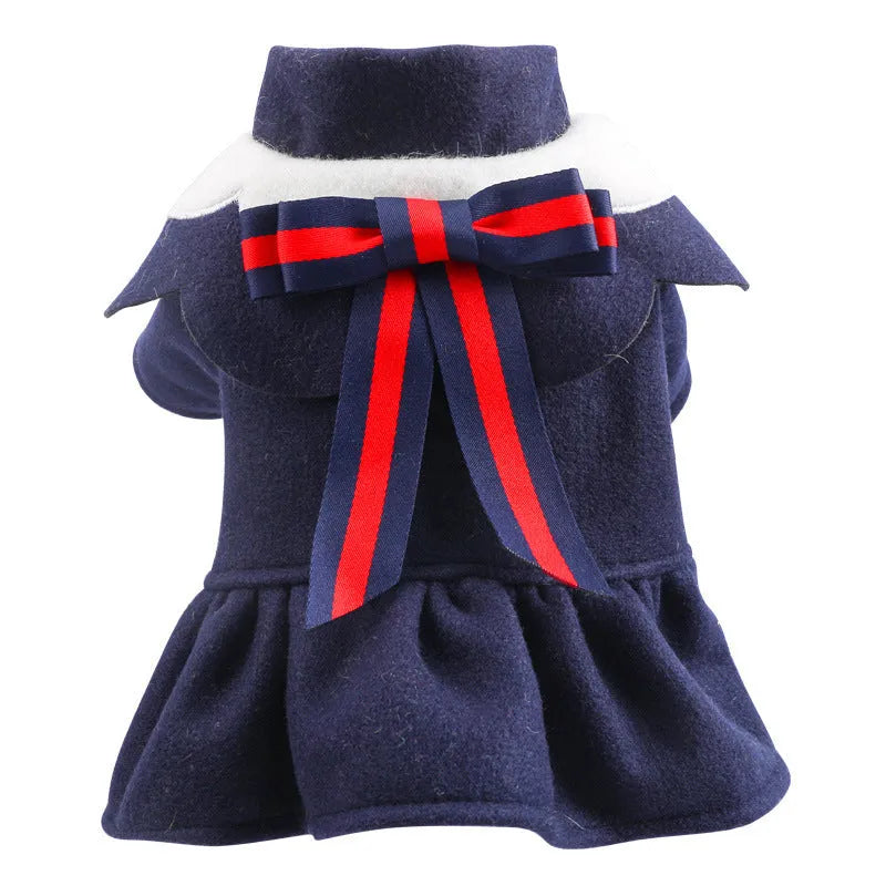Pet dog or cat wearing a navy blue British-style woolen cloth skirt costume on a neutral background