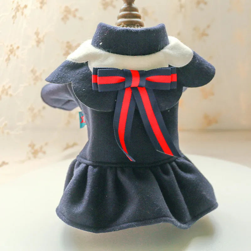 Pet dog or cat wearing a navy blue British-style woolen cloth skirt costume on a neutral background