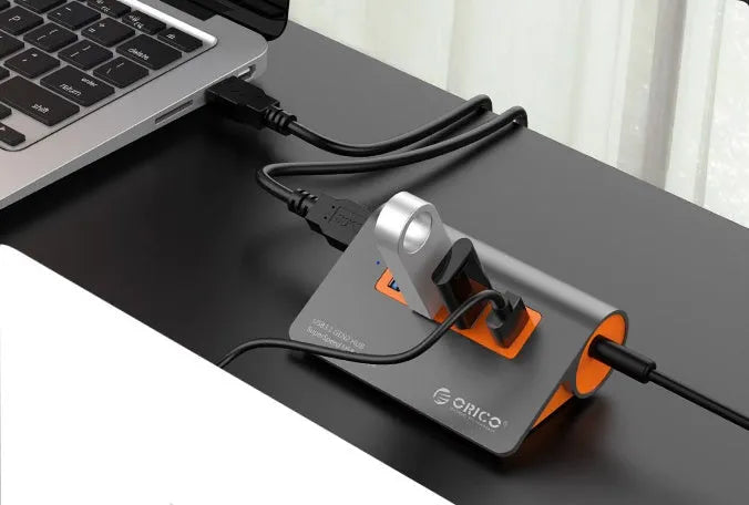 Dark grey and orange aluminium USB 3.1 hub with four ports and individual power switches