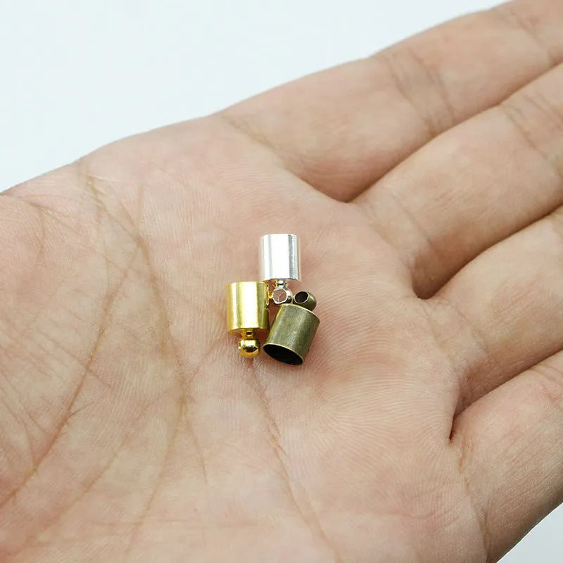 Assortment of multi-colour copper caps in gold, silver, black, and bronze finishes for jewellery making.