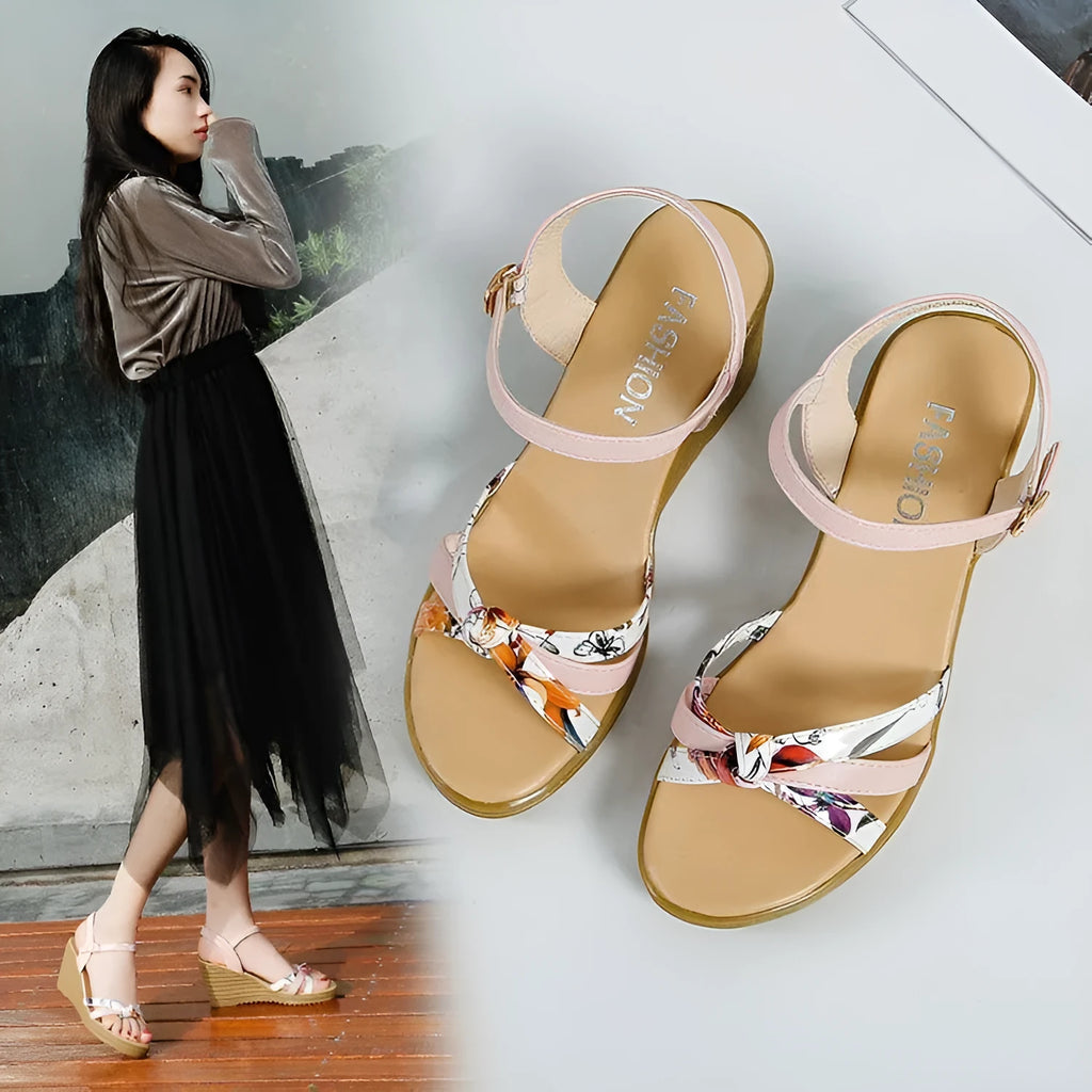 Pink women's wedge sandals with a thick heel, fish mouth design, and a silver buckle.