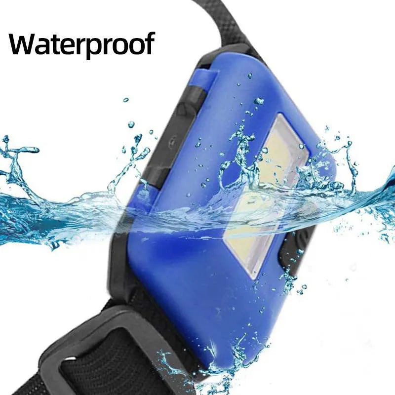 Outdoor mini COB LED headlamp in black, blue, or red on adjustable polyester strap.