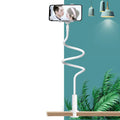 Blue mobile phone and tablet holder with flexible memory alloy hose positioned on a bedside table.