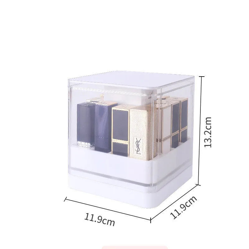 Clear press lift lipstick storage box with dust cover on a desktop, shown in pink and white.