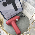 God fascia gun muscle massager in black, red, or grey colour with USB cable for power.