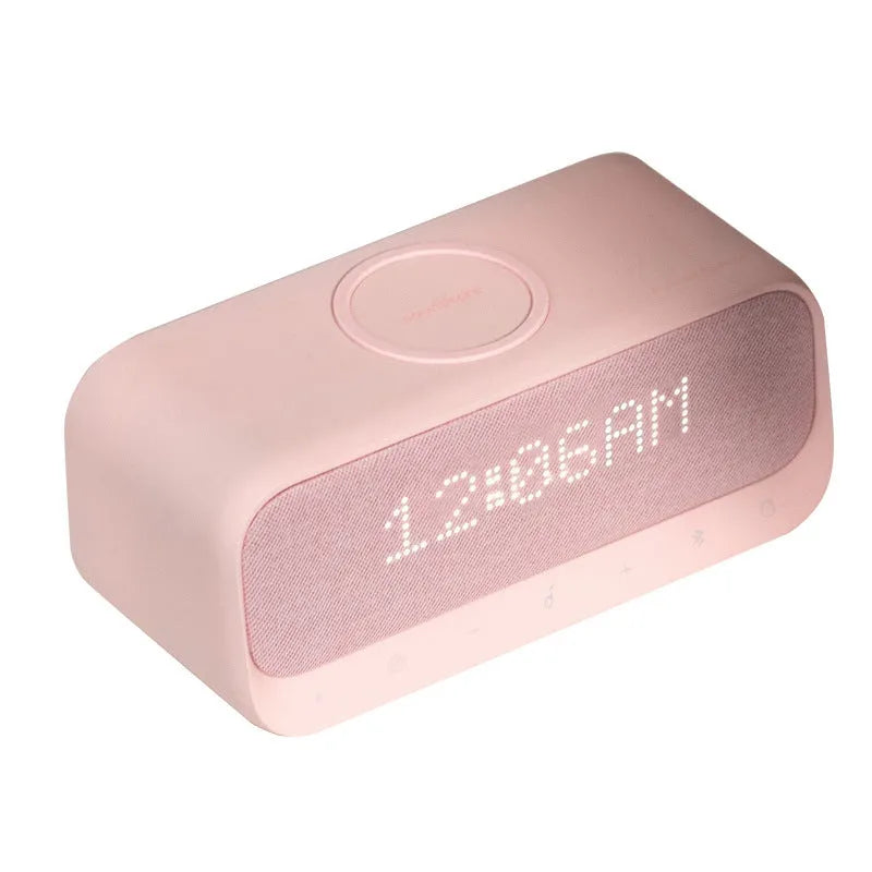 White Soundcore Bluetooth speaker with wireless charging top, digital display, and compact vertical design.