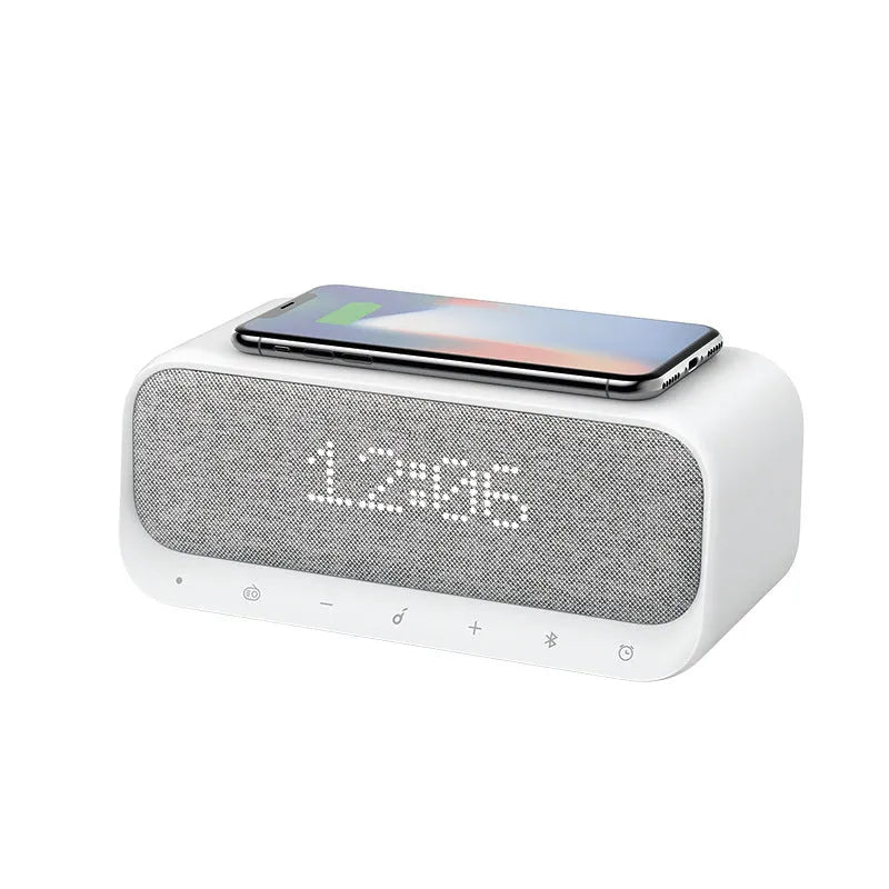 White Soundcore Bluetooth speaker with wireless charging top, digital display, and compact vertical design.