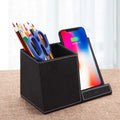 Black leather desk organiser with wireless phone charging surface and pen holder compartment