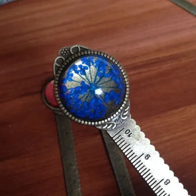 Handmade dried flower bookmark with ruler showing lace flowers, daffodils, and clover at 12cm length