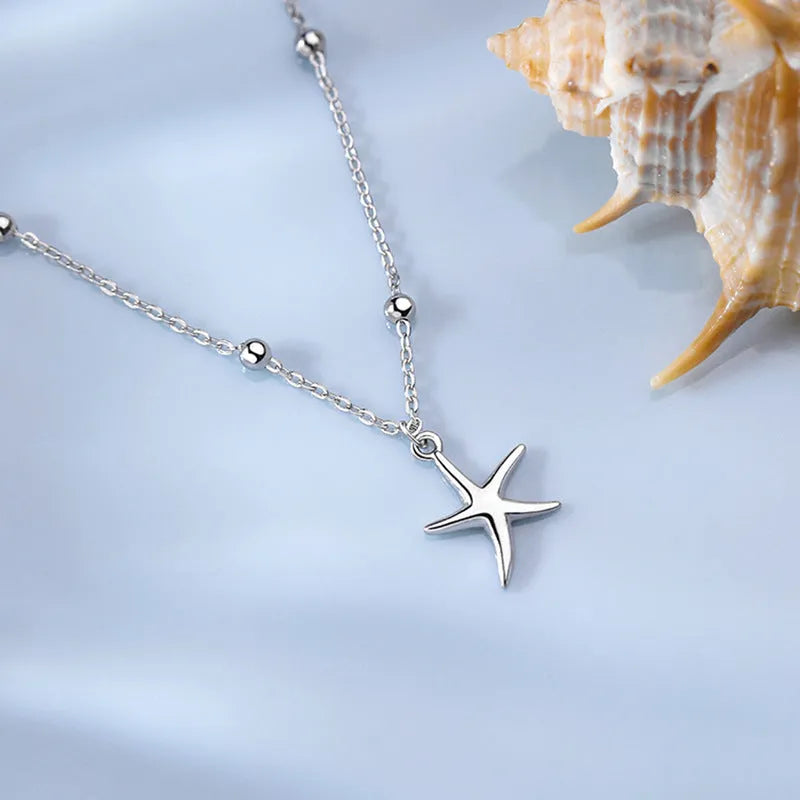 Close-up of a women's S925 sterling silver anklet with a starfish charm and round beads on an adjustable chain.