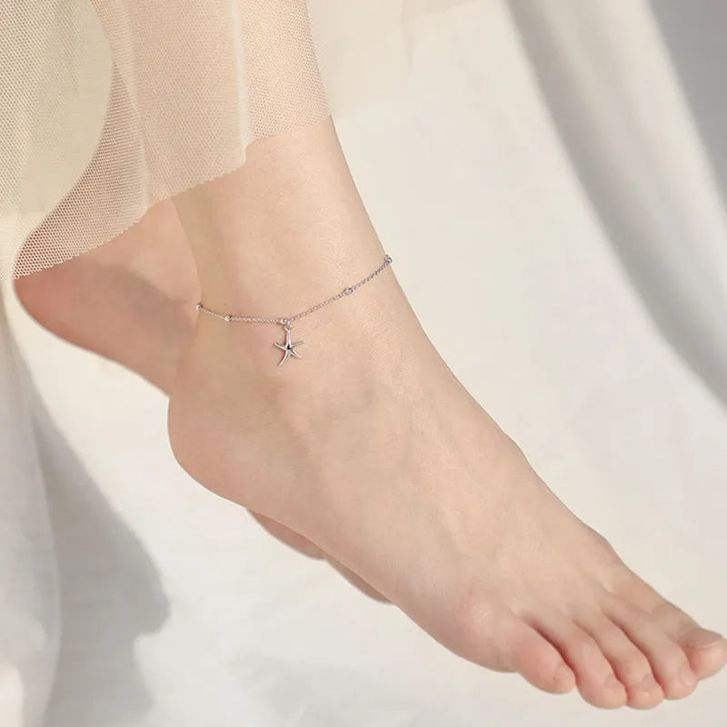Close-up of a women's S925 sterling silver anklet with a starfish charm and round beads on an adjustable chain.