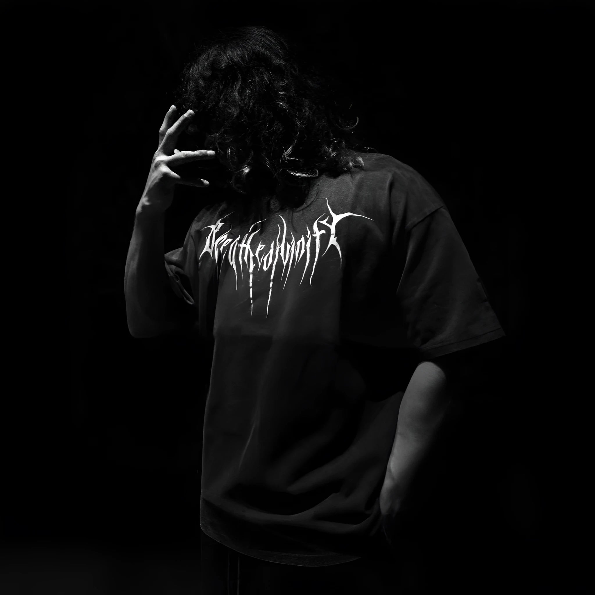 Dark coloured loose fit cotton T-shirt with short sleeves and glitter craft detail on a hanger.