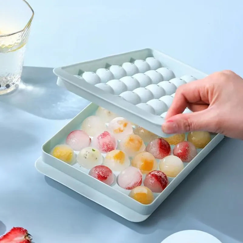 Blue silicone ice cube tray with lid showing 33 round moulds for homemade ice