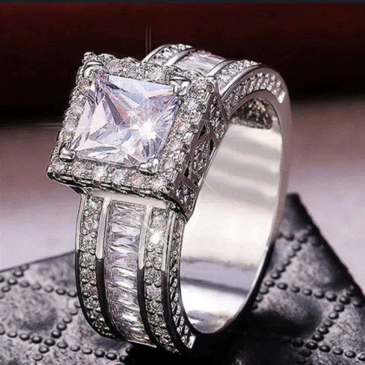 Geometric silver-coloured women's ring with round design elements on a finger, shown in gold and white colour options.