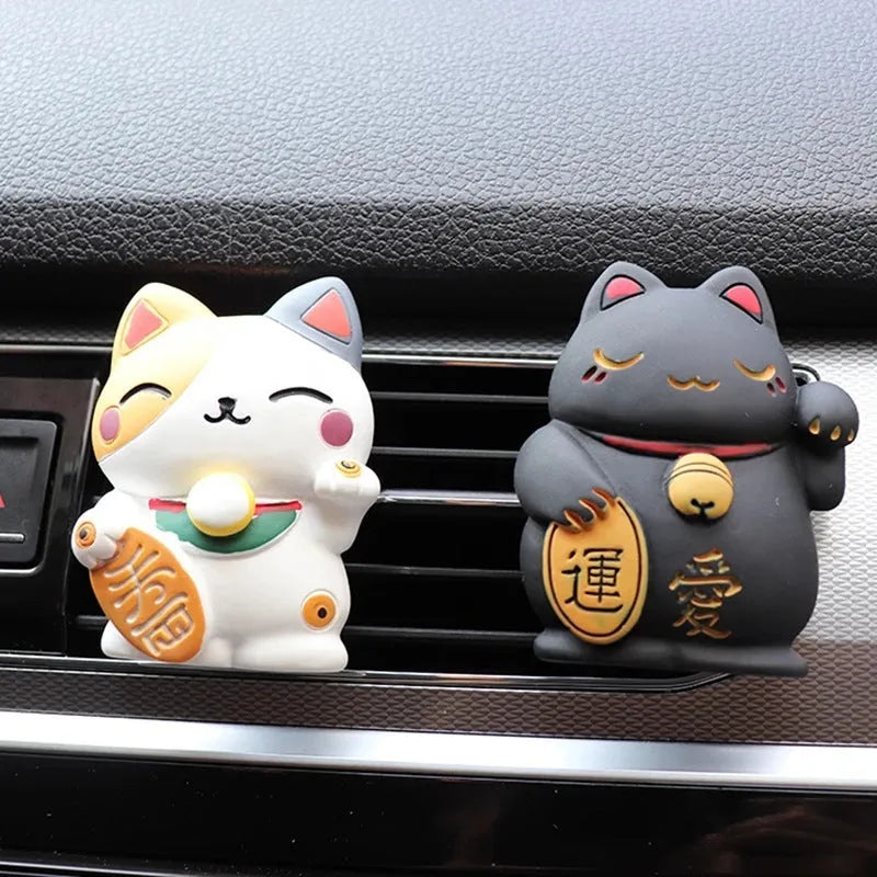 Black cat and white cat resin car vent clip aromatherapy diffuser on a car air conditioning vent.