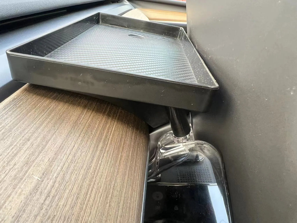 Black ABS plastic storage box installed under the screen of a Tesla Model Y centre console.