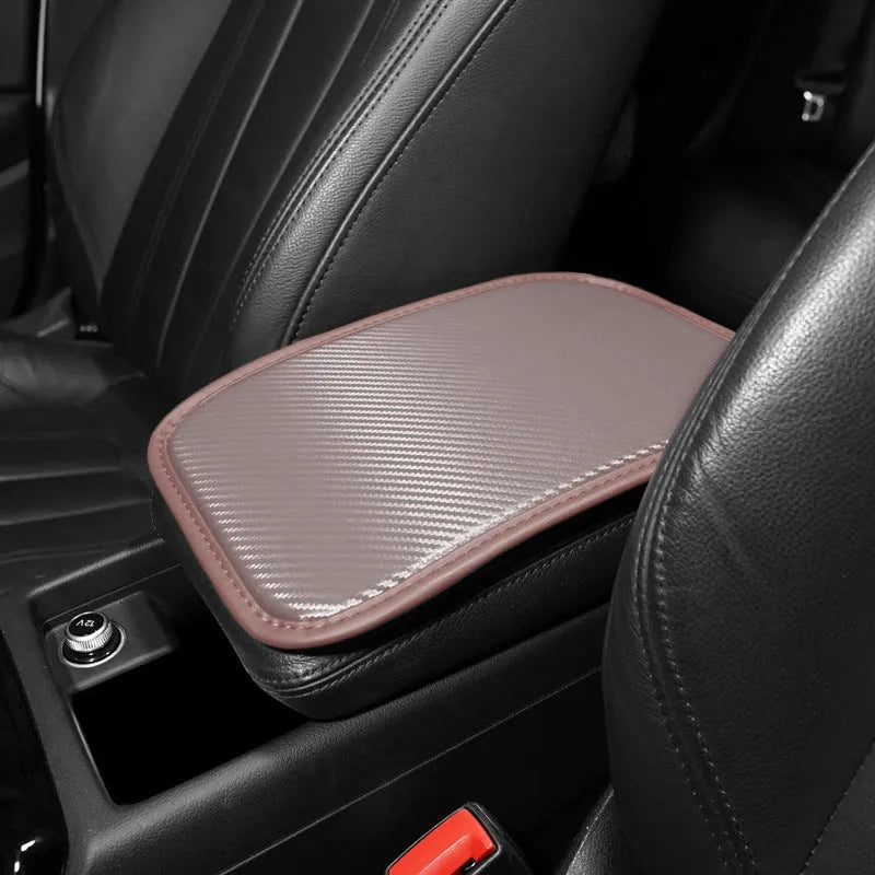 Automotive carbon fibre armrest box mat in black leather, 29x19cm, on a car centre console