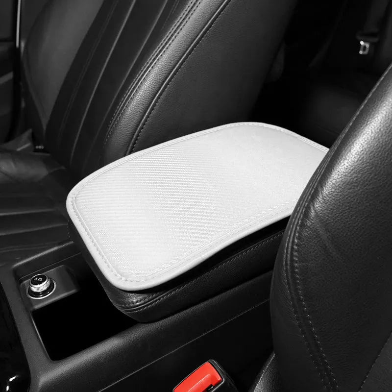 Automotive carbon fibre armrest box mat in black leather, 29x19cm, on a car centre console