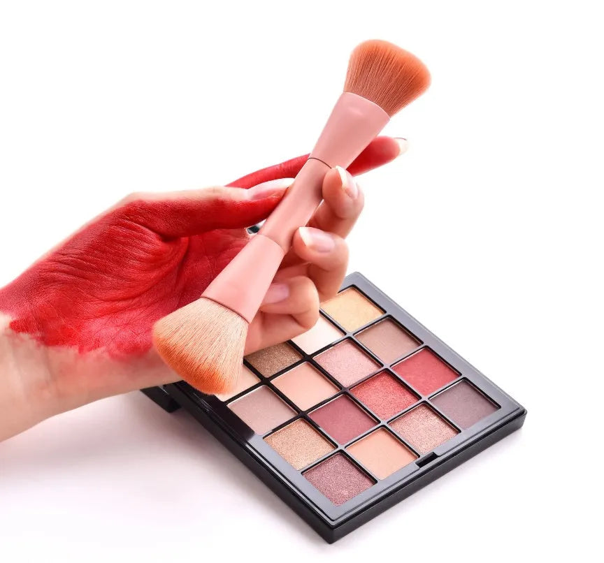 Ten professional makeup brushes with wooden handles in a pink box, including powder, foundation, and double-ended brushes.